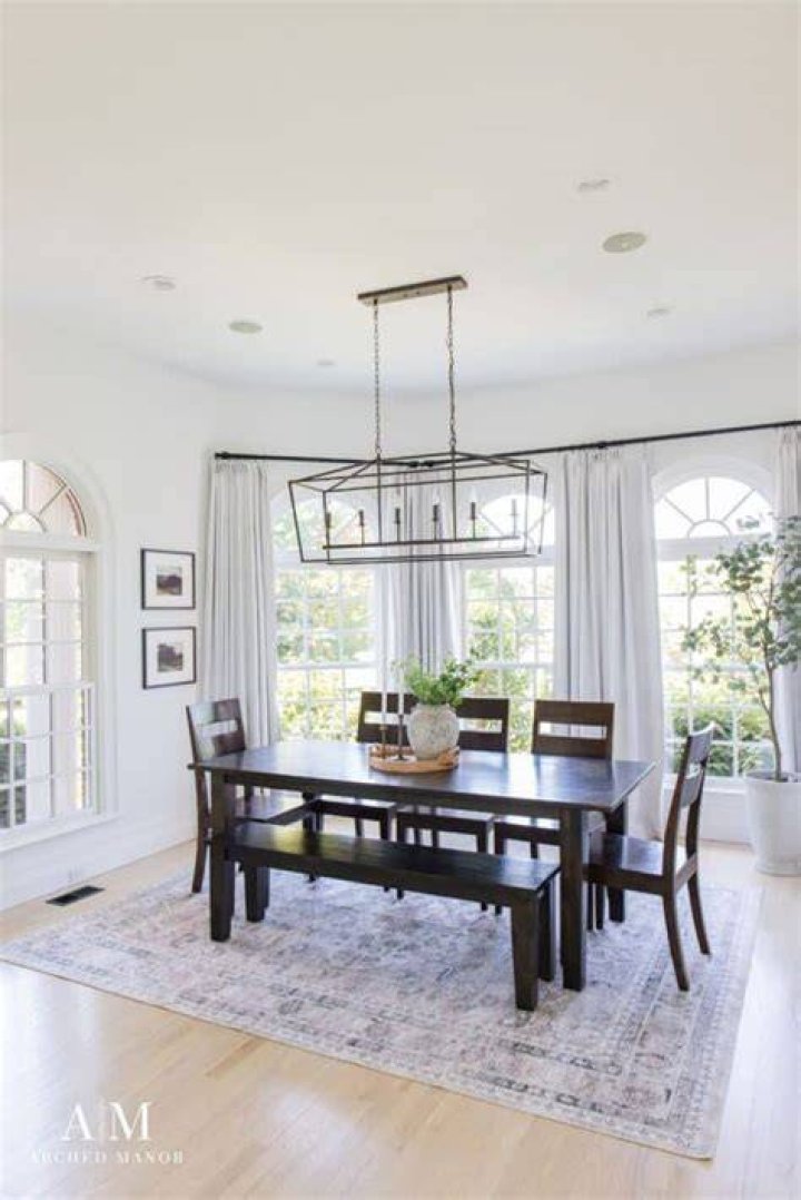 How far down should a chandelier hang over a dining table?