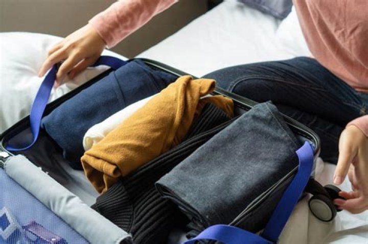 Is it better to roll or fold clothes in a suitcase?